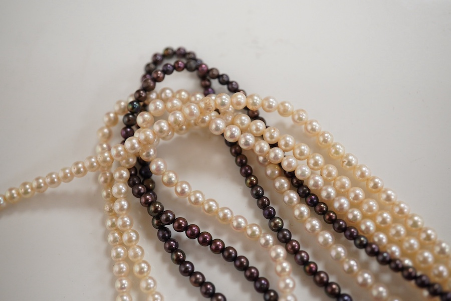 A cultured pearl, ruby and diamond necklace, the clasp set with oval rubies and brilliant-cut diamonds, to a six-strand torsade necklace of cultured pearls of black and white tints, necklace length 61cm, clasp length 2.5